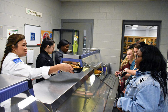 Chef Uno Immanivong serves students in a cafeteria