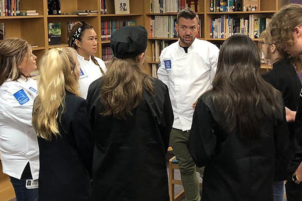 Chefs Todd Erickson, Deb Hey and Uno Immanivong speak with cafeteria staff